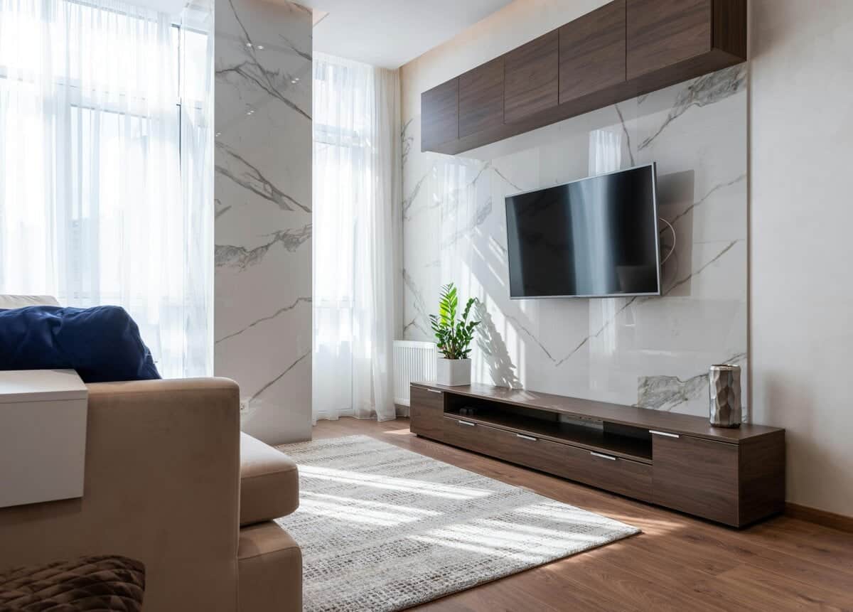 Modern living room with marble wall decor, TV unit, and sleek wooden cabinetry – Sorse Furniture style.